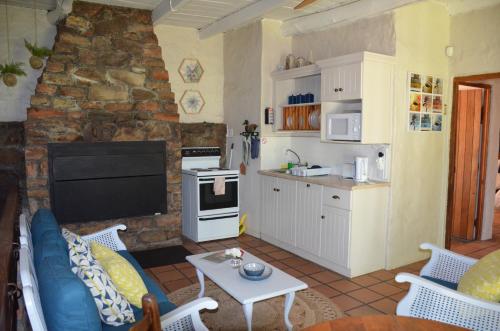 Il dispose d'une cuisine et d'un salon avec un canapé et une table. dans l'établissement Houdenbek Farm Cottages, à Ceres