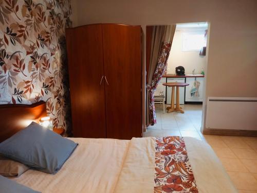 1 dormitorio con 1 cama y armario de madera en Maisonnette bretonne en Quemper-Guézennec