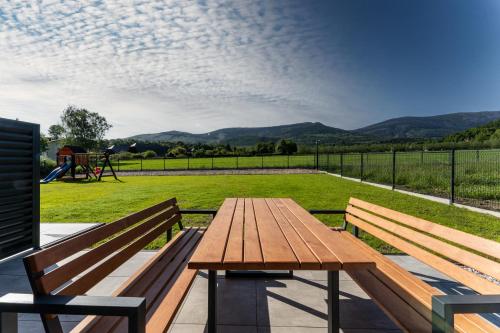 a picnic table with two benches and a playground at Domki Słoneczna 11 z widokiem na Śnieżkę in Karpacz