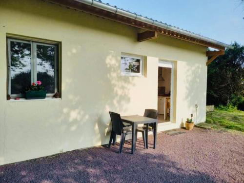 a table and chairs in front of a house at Maisonnette bretonne in Quemper-Guézennec