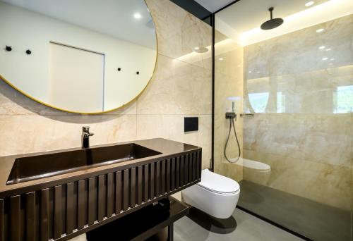 a bathroom with a sink and a toilet and a mirror at Marinus Beach Hotel in Marina