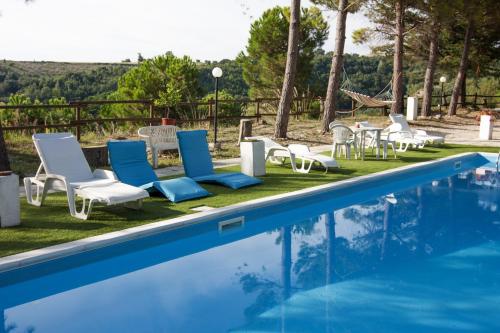 a swimming pool with lounge chairs and a table at Il Corbezzolo in Ripatransone