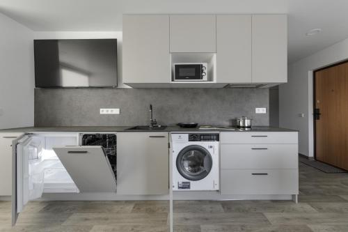 uma cozinha com uma máquina de lavar roupa e uma máquina de lavar roupa em Mini-Home Apartamentai em Klaipėda