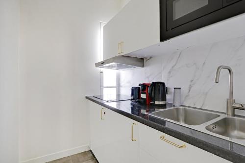 a kitchen with a sink and a counter top at Pick A Flat's Apartment in Jardin du Luxembourg - Rue Royer Collard in Paris