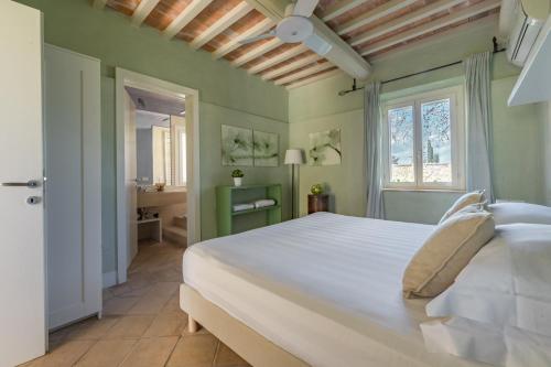 a bedroom with a large white bed and a bathroom at Le Versegge Resort in Braccagni