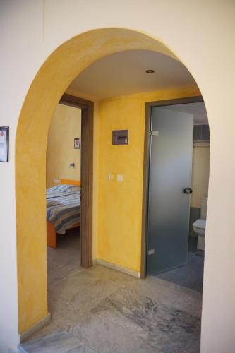 an archway in a room with a bed and a bedroom at Katerini Apartments Hotel in Platanes