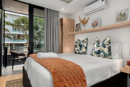 a bedroom with a large bed and a large window at Station House Apartments in Cape Town