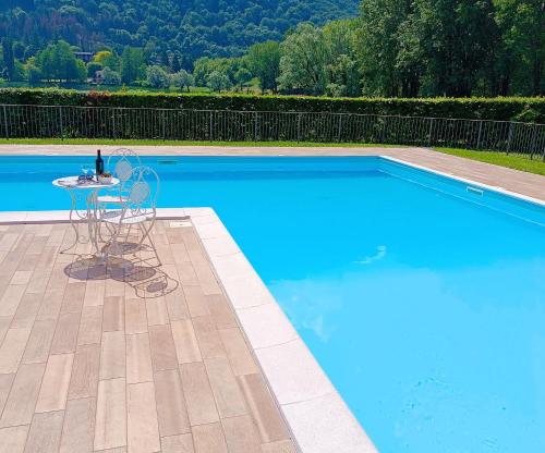 a table and chair next to a blue swimming pool at Casa Vacanze Alessandro in Spinone Al Lago