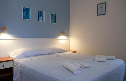 a white bed with two white towels on it at Hotel Vienna in Cervia