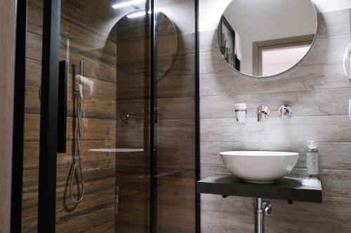 ein Bad mit einem Waschbecken und einem Spiegel in der Unterkunft Hotel Vienna in Cervia