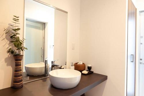 a bathroom with a large white sink and a mirror at Maravilla in Nakijin