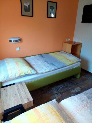 a room with two beds and a wooden bench at Hotel Olga in Slavkov u Brna
