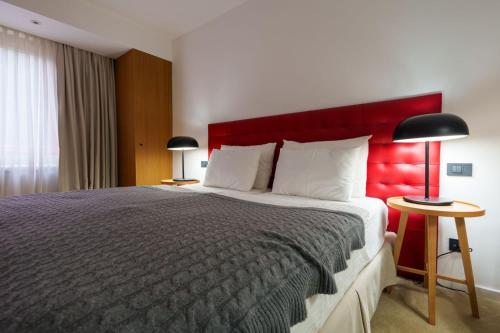 a bedroom with a large bed with a red headboard at Hotel Palisad in Zlatibor