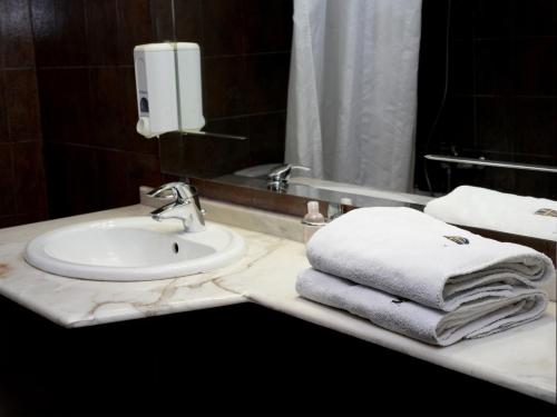 فندق مربيلا في جونية: حمام مع حوض ومناشف على كاونتر