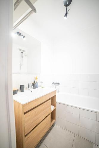 une salle de bain avec un lavabo et une baignoire dans l'établissement Le Cosy WIFI CLIM JARDIN TOP PROS SERVICESConciergerie MONTPELLIER, à Montpellier