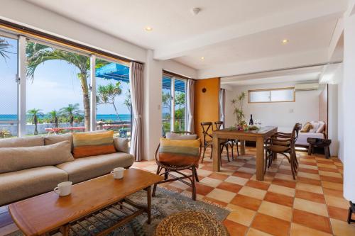 恩納的住宿－海まで徒歩1分 沖縄でも珍しい絶景ホテル 贅沢プライベートビーチ付き ビーチルーム，客厅配有沙发和桌子