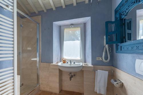 a blue bathroom with a sink and a shower at Le Versegge Resort in Braccagni