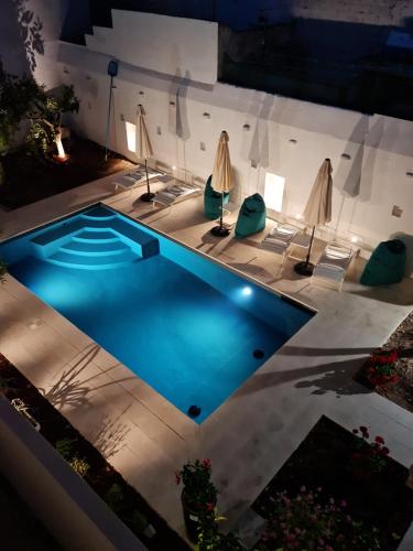 a pool at night with chairs and umbrellas at Palazzo Rodio in Ostuni