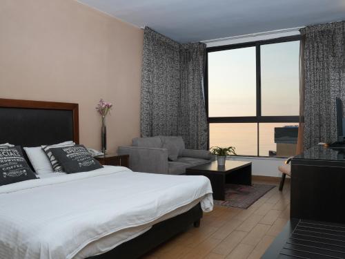 ein Schlafzimmer mit einem Bett und ein Wohnzimmer in der Unterkunft Marbella Hotel in Jounieh