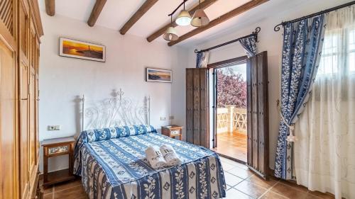 een slaapkamer met een bed en een groot raam bij Casa Los Morales Ronda by Ruralidays in Ronda