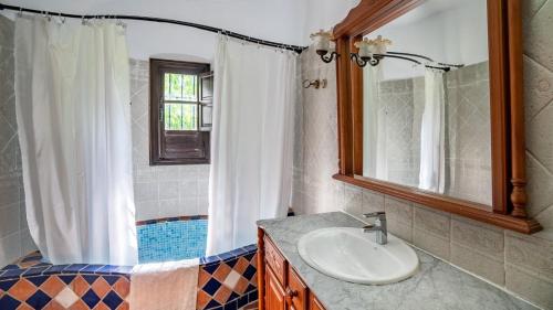 een badkamer met een wastafel en een spiegel bij Casa Los Morales Ronda by Ruralidays in Ronda