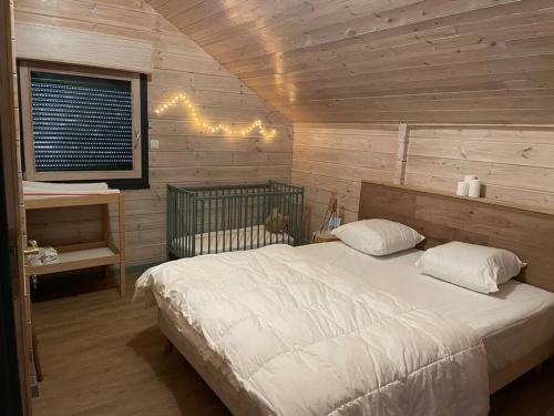 a bedroom with a white bed and a window at Le chalet blanc de Gerardmer avec Spa in Gérardmer