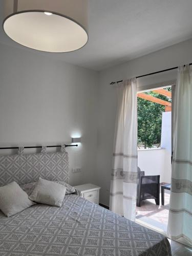 a bedroom with a bed and a large window at Sa Jacca Albergo Rurale in Siniscola