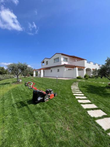 a lawn mower laying on the grass in front of a house at Sa Jacca Albergo Rurale in Siniscola