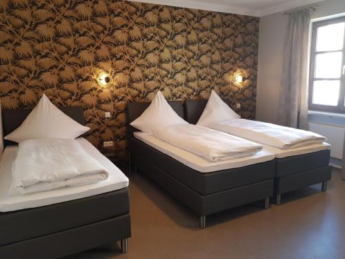 two twin beds in a room with a wall at Boardinghouse Marktplatz in Schwandorf in Bayern