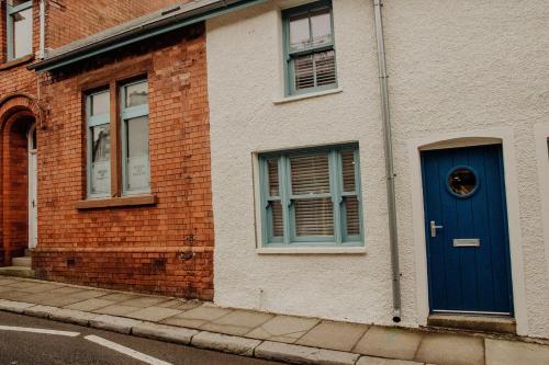 a brick building with a blue door on a street at The Old Brewery, Ulverston in Ulverston