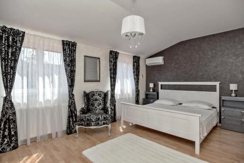 um quarto com uma cama branca e uma cadeira em Villa Cotabela em Omiš