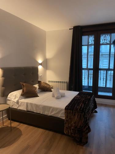 a bedroom with a bed and a large window at Hostal Arenal Madrid in Madrid