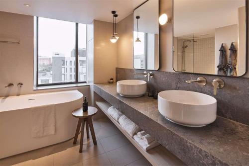 a bathroom with two sinks and a large mirror at Rydges Melbourne in Melbourne