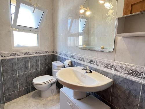 uma casa de banho com um lavatório, um WC e um espelho. em Villa Bassetes By El Conserje em Denia