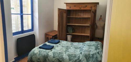 a bedroom with a bed with blue pillows on it at Ancien relais de chasse à 35 min du Circuit 24h du Mans in Le Lude