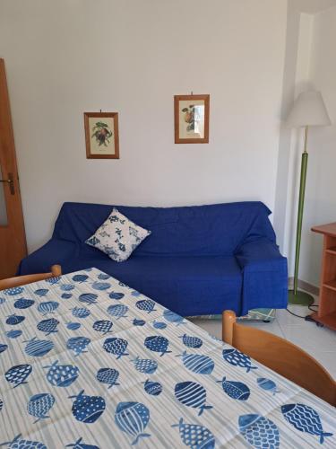 a blue couch and a bed in a room at Il rifugio del marinaio in Mascali