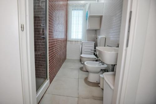 a bathroom with three toilets and two sinks and a shower at Villa Benedetta in Ostuni