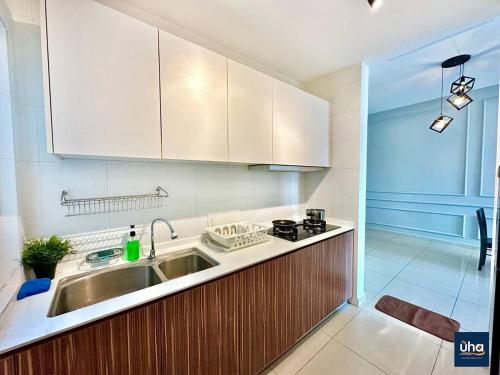 a kitchen with a sink and a stove and cabinets at Seasons Luxury Apartment By RR JBcity in Johor Bahru