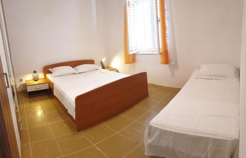 a bedroom with two beds and a window at Seaside Stay Rošić 2 in Ivan Dolac