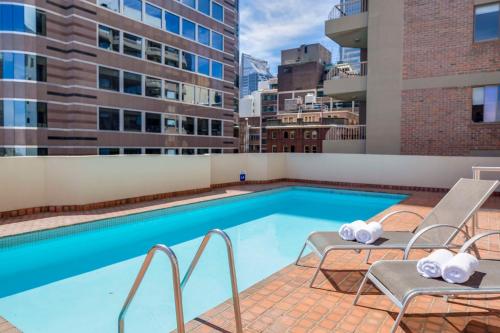 a swimming pool on the roof of a building at Metro Apartments on King in Sydney
