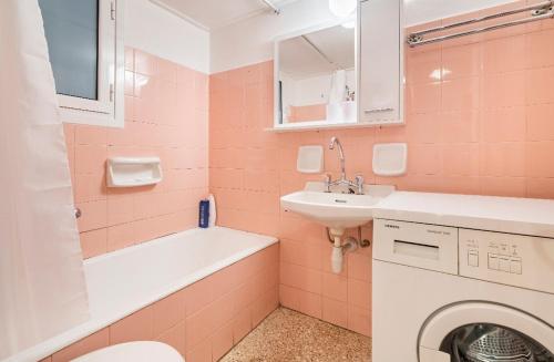 a pink bathroom with a sink and a washing machine at Billy's Home Ano Patisia, Athens in Athens