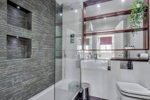 a bathroom with a shower and a sink and a toilet at 3 bed apartment near Old Street and City of London in London