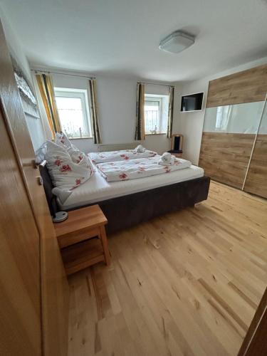 a bedroom with a bed and a wooden floor at Babsi Appartments - leben am Land in Wels