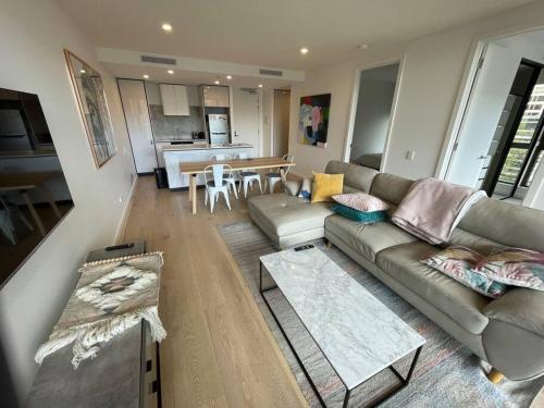 sala de estar con sofá y mesa en Lovely CBD two bedroom apartment free parking en Canberra