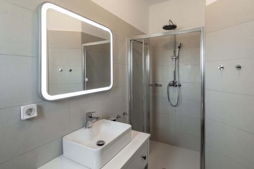 a bathroom with a sink and a shower with a mirror at Sunset Village 1 in Paleochori