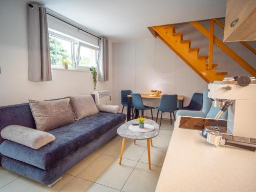 Duna Apartments Štúrovo في شتوروفو: غرفة معيشة مع أريكة زرقاء وطاولة