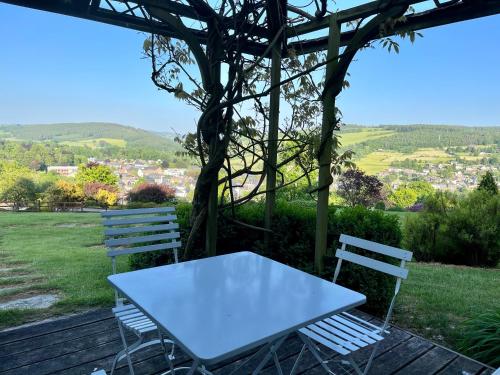 a white table and two chairs sitting on a deck at La Borzeux in Stavelot