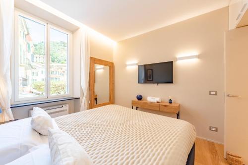 um quarto com uma cama e uma televisão na parede em San Giorgio Uno 60mq 1b/1b em Portofino
