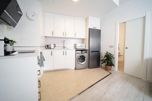 a kitchen with a refrigerator and a washing machine at TwinSuites Malaga in Málaga