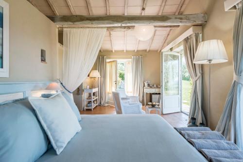 a bedroom with a bed and a living room at Dimora Santa Margherita - Relais di Charme in Cinigiano